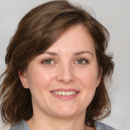 Joyful white young-adult female with medium  brown hair and blue eyes