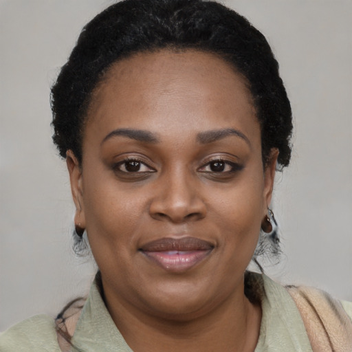 Joyful black young-adult female with short  black hair and brown eyes
