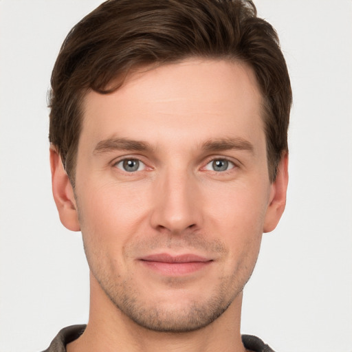 Joyful white young-adult male with short  brown hair and grey eyes