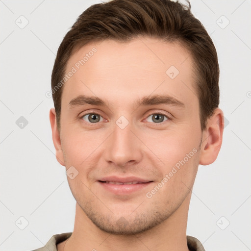 Joyful white young-adult male with short  brown hair and grey eyes