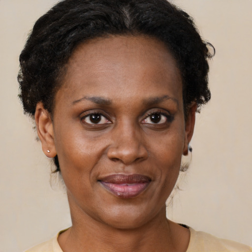 Joyful black adult female with short  brown hair and brown eyes
