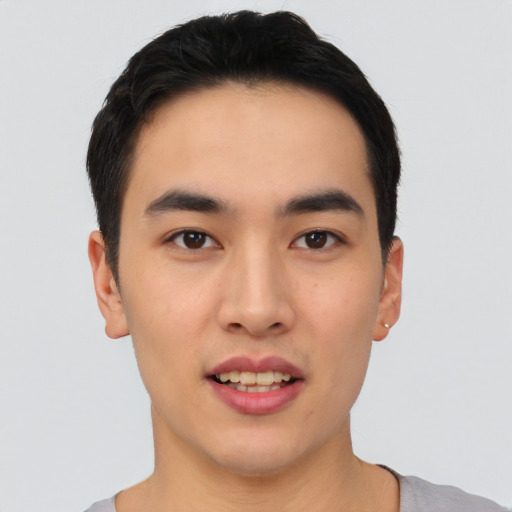 Joyful asian young-adult male with short  black hair and brown eyes