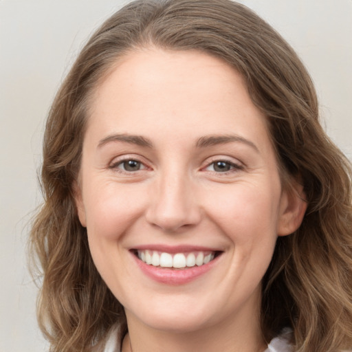 Joyful white young-adult female with medium  brown hair and green eyes