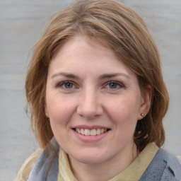 Joyful white young-adult female with medium  brown hair and grey eyes