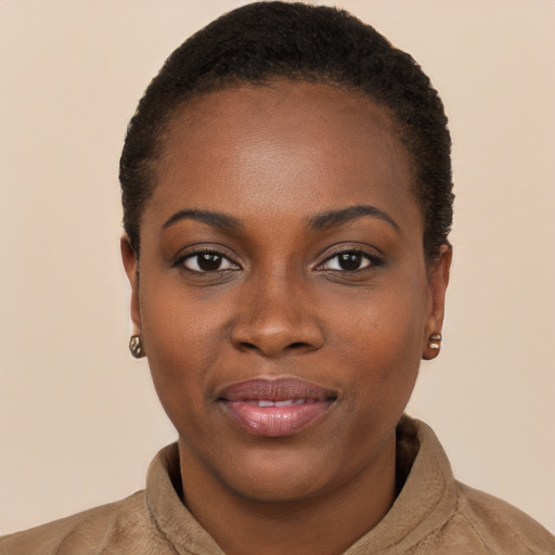 Joyful black young-adult female with short  brown hair and brown eyes