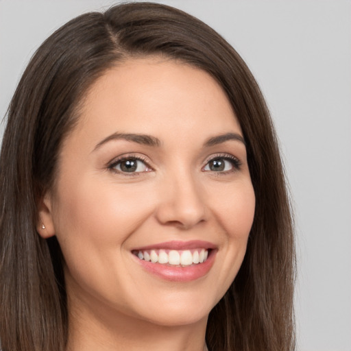 Joyful white young-adult female with long  brown hair and brown eyes