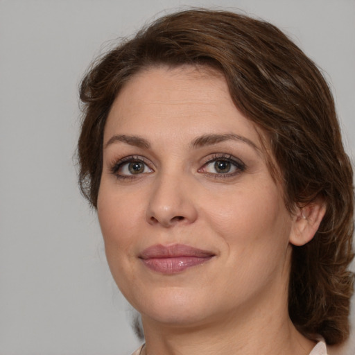 Joyful white young-adult female with medium  brown hair and green eyes