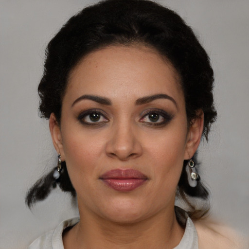 Joyful latino young-adult female with medium  brown hair and brown eyes