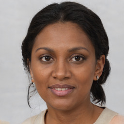 Joyful black adult female with medium  brown hair and brown eyes