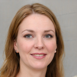 Joyful white young-adult female with long  brown hair and blue eyes