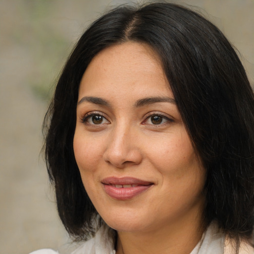 Joyful latino adult female with medium  brown hair and brown eyes