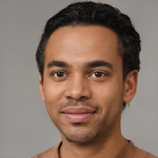 Joyful latino young-adult male with short  black hair and brown eyes