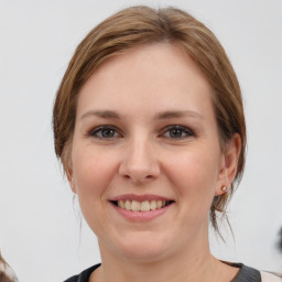 Joyful white young-adult female with medium  brown hair and grey eyes