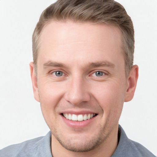 Joyful white young-adult male with short  brown hair and grey eyes