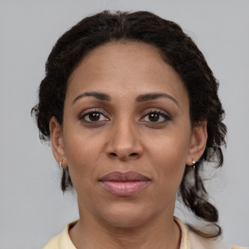 Joyful black adult female with medium  brown hair and brown eyes