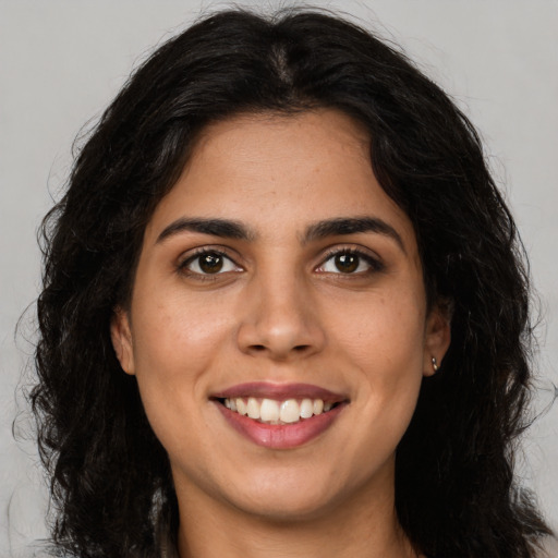 Joyful latino young-adult female with long  brown hair and brown eyes