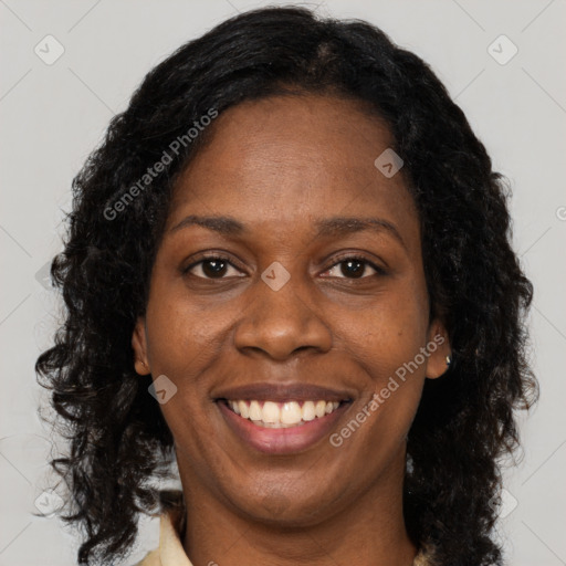 Joyful black adult female with long  brown hair and brown eyes