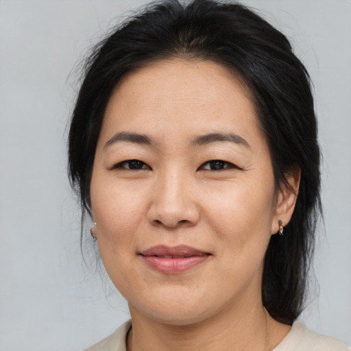 Joyful asian adult female with medium  brown hair and brown eyes