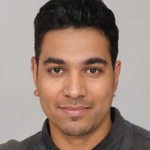 Joyful latino young-adult male with short  black hair and brown eyes