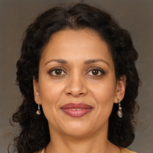 Joyful black adult female with long  brown hair and brown eyes