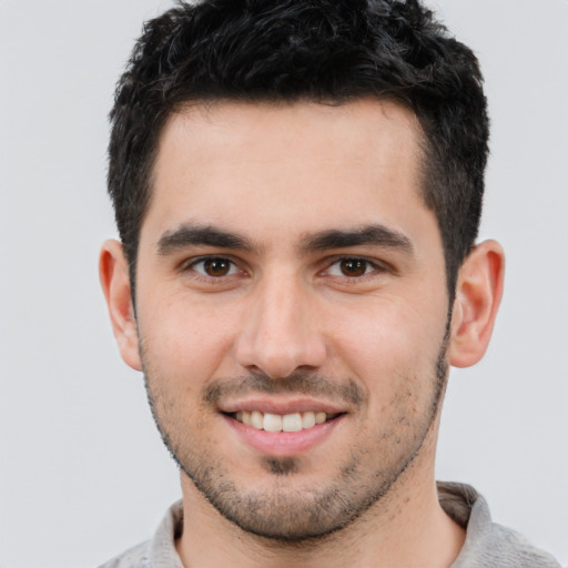 Joyful white young-adult male with short  black hair and brown eyes