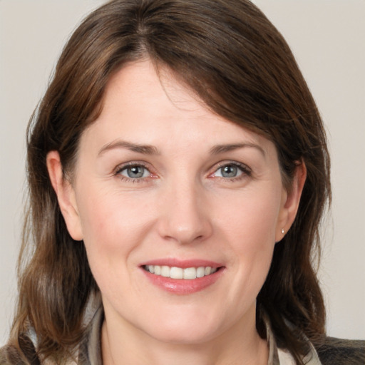 Joyful white young-adult female with medium  brown hair and grey eyes