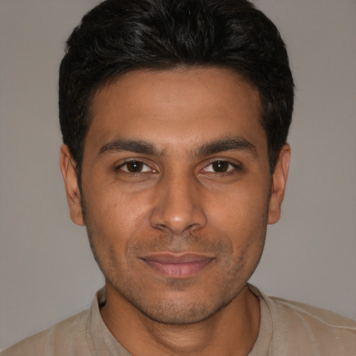 Joyful white young-adult male with short  black hair and brown eyes