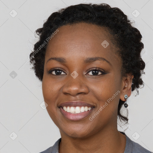 Joyful black young-adult female with long  brown hair and brown eyes