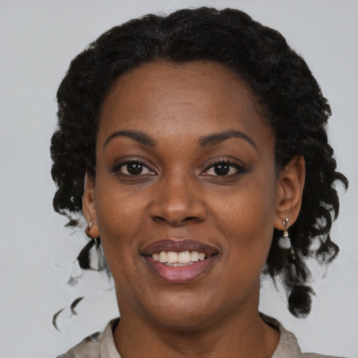 Joyful black adult female with medium  black hair and brown eyes