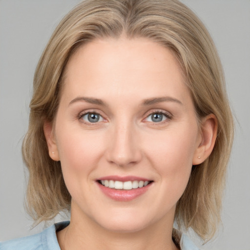 Joyful white young-adult female with medium  brown hair and blue eyes