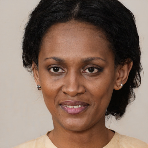 Joyful black adult female with medium  black hair and brown eyes