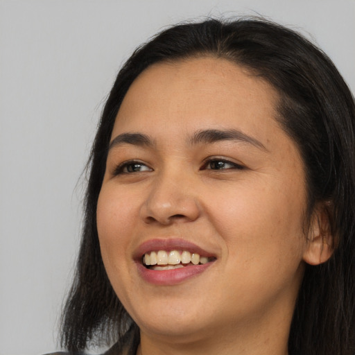 Joyful asian young-adult female with long  black hair and brown eyes