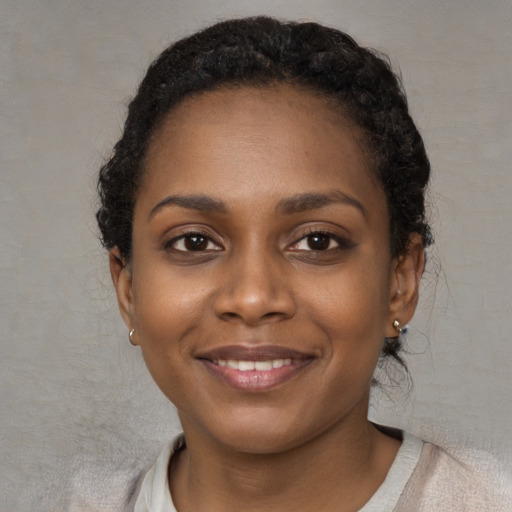 Joyful black young-adult female with short  black hair and brown eyes