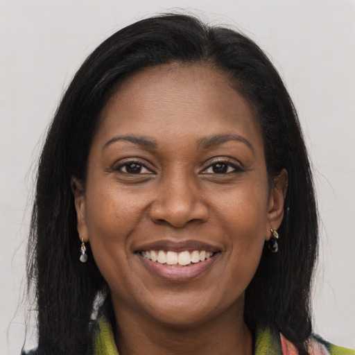 Joyful black young-adult female with long  brown hair and brown eyes
