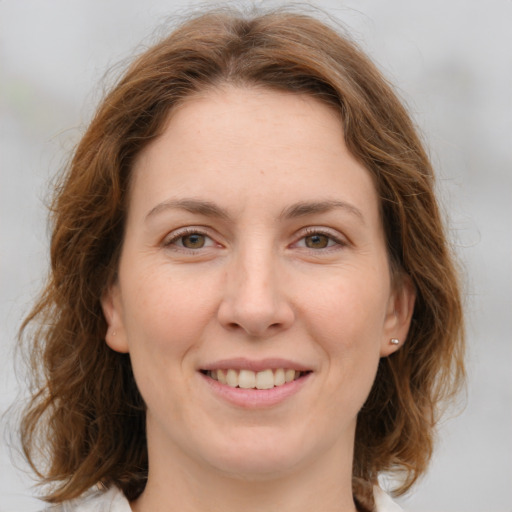 Joyful white young-adult female with medium  brown hair and green eyes