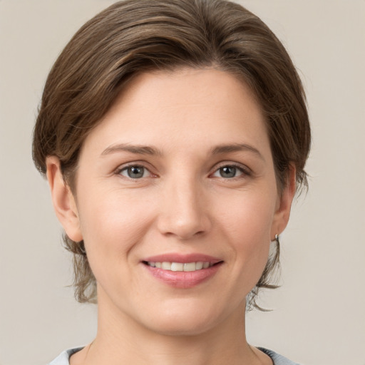 Joyful white young-adult female with medium  brown hair and grey eyes