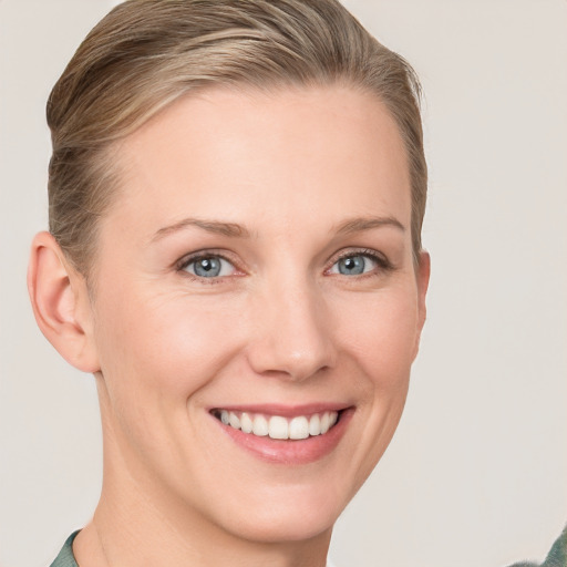 Joyful white young-adult female with short  brown hair and blue eyes