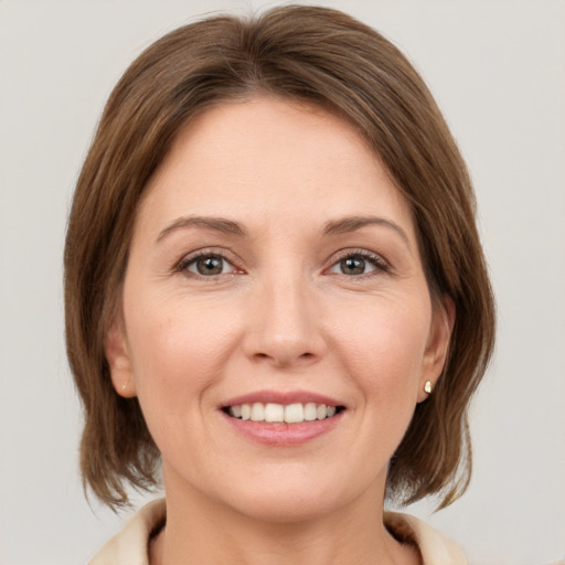 Joyful white young-adult female with medium  brown hair and grey eyes