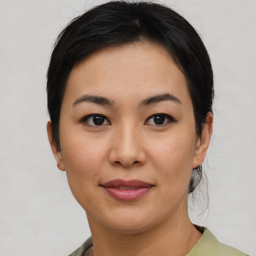 Joyful asian young-adult female with short  black hair and brown eyes
