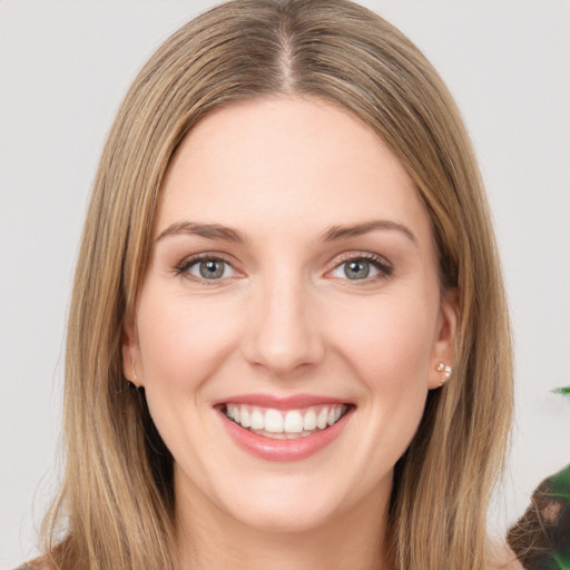 Joyful white young-adult female with long  brown hair and green eyes