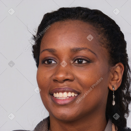 Joyful black young-adult female with long  black hair and brown eyes