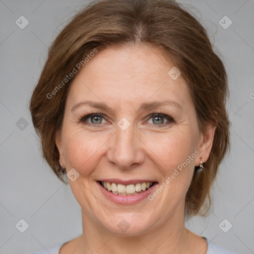 Joyful white adult female with medium  brown hair and grey eyes