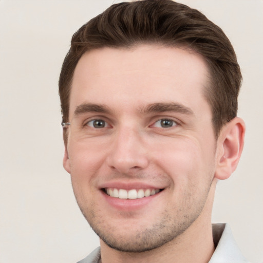 Joyful white young-adult male with short  brown hair and grey eyes