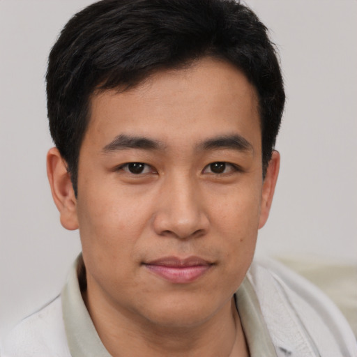 Joyful asian young-adult male with short  black hair and brown eyes