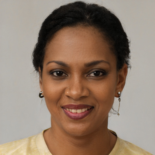 Joyful black young-adult female with short  black hair and brown eyes