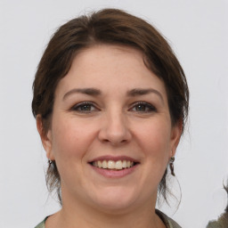 Joyful white young-adult female with medium  brown hair and grey eyes