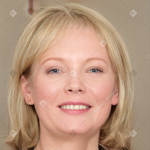 Joyful white adult female with medium  blond hair and blue eyes