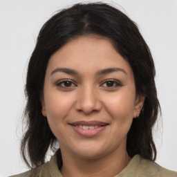 Joyful latino young-adult female with long  brown hair and brown eyes