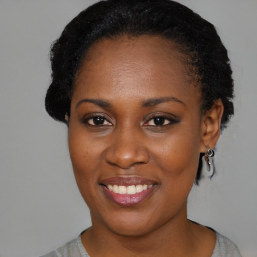 Joyful black young-adult female with short  black hair and brown eyes