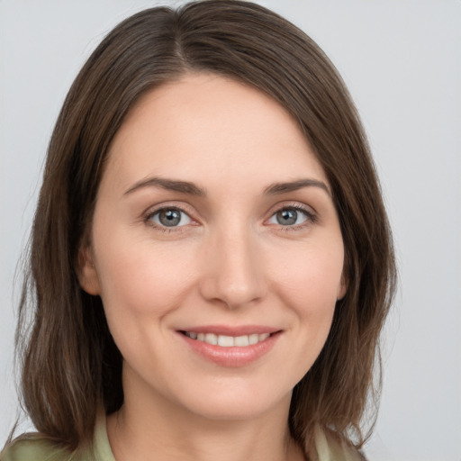 Joyful white young-adult female with medium  brown hair and grey eyes